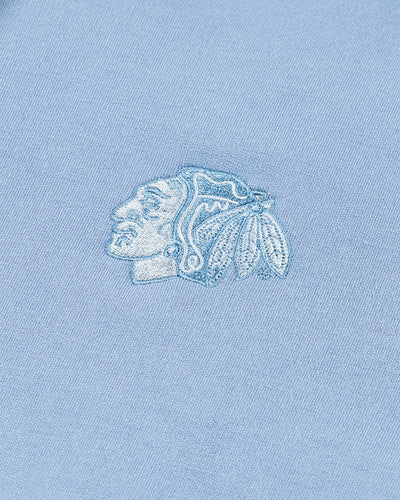 light blue TravisMathew hoodie with Chicago Blackhawks tonal primary logo embroidered on left chest - detail lay flat