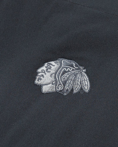two tone black and grey TravisMathew vest with Chicago Blackhawks primary logo embroidered on back yoke - detail lay flat