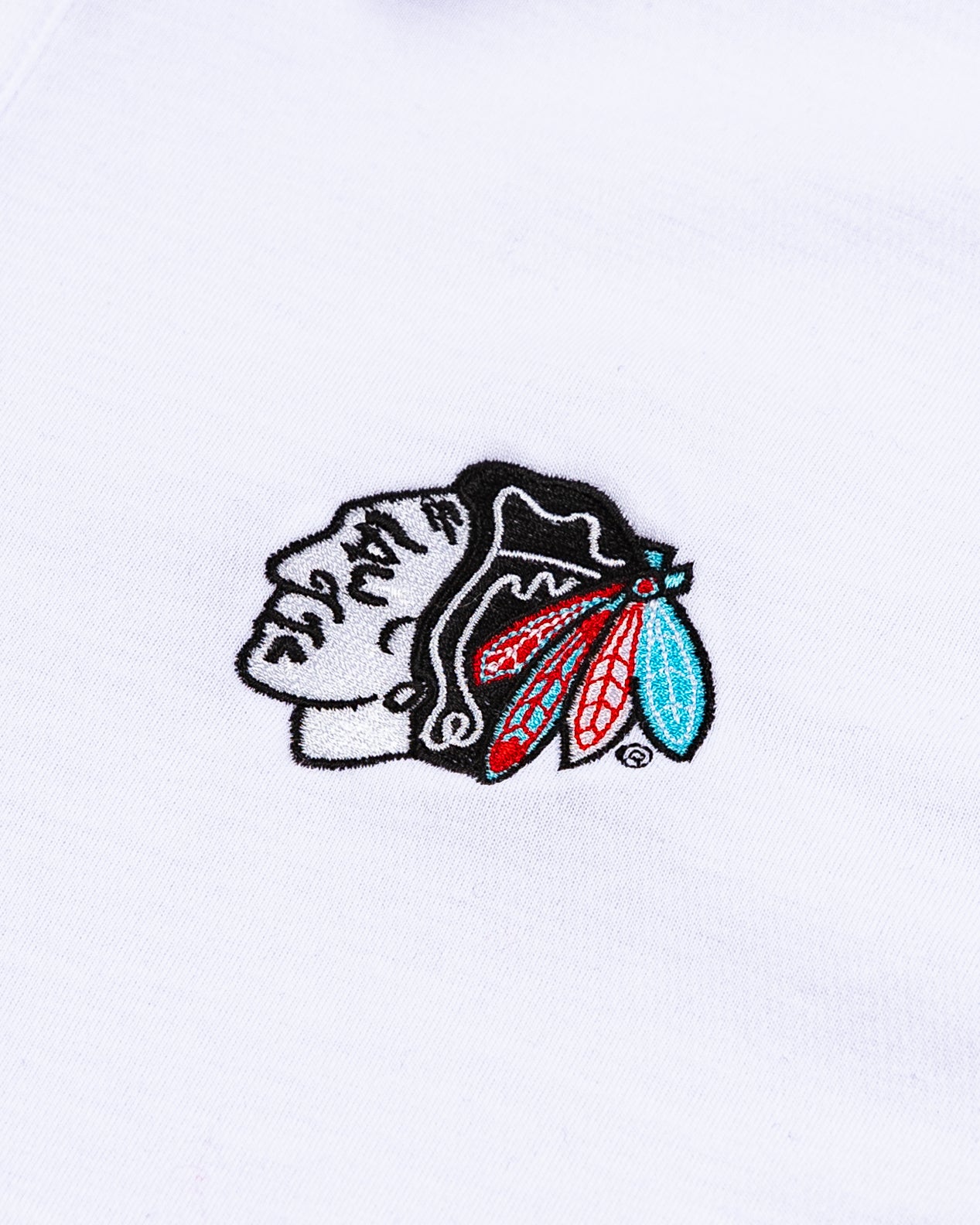 white TravisMathew polo with tonal Chicago Blackhawks primary logo embroidered on left chest - detail lay flat
