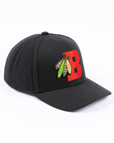 black Mitchell & Ness snapback with Chicago Blackhawks four feathers logo embroidered on red letter B - right angle lay flat