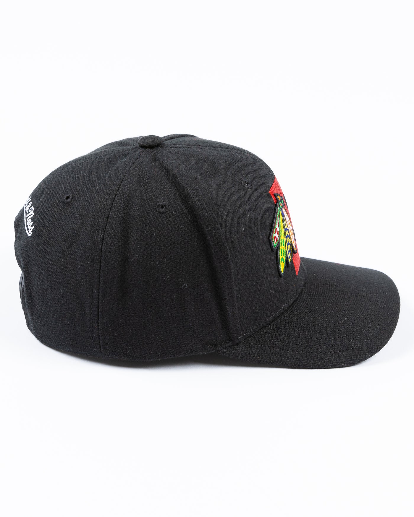 black Mitchell & Ness snapback with Chicago Blackhawks four feathers logo embroidered on red letter B - right side lay flat