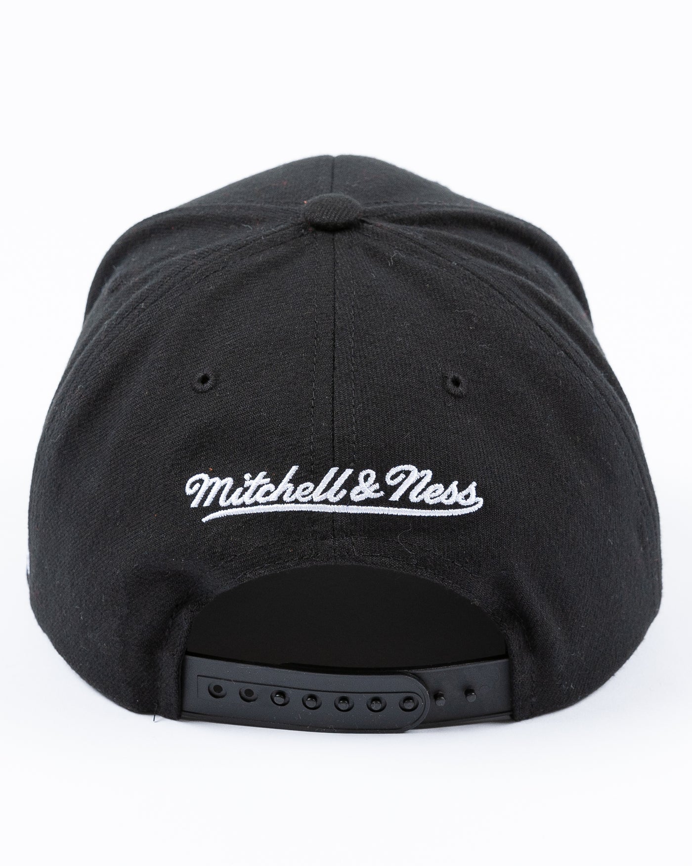 black Mitchell & Ness snapback with Chicago Blackhawks four feathers logo embroidered on red letter B - back lay flat