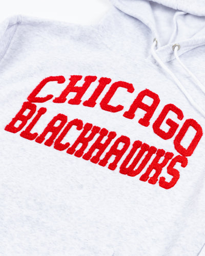 light grey zoozatz women's hoodie with red chenille Chicago Blackhawks wordmark across chest - detail lay flat