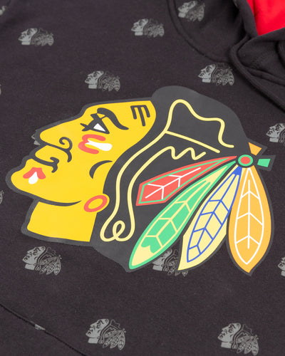 black Mitchell & Ness hoodie with all over Chicago Blackhawks primary logo all over printed with primary logo printed on center chest - detail lay flat