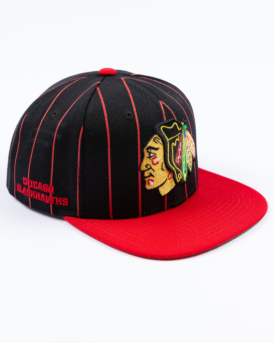 black and red Mitchell & Ness snapback cap with embroidered Chicago Blackhawks primary logo embroidered on front - right angle lay flat