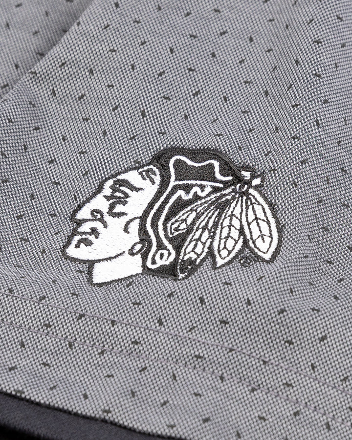 grey TravisMathew polo with Chicago Blackhawks tonal primary logo on left sleeve - detail lay flat