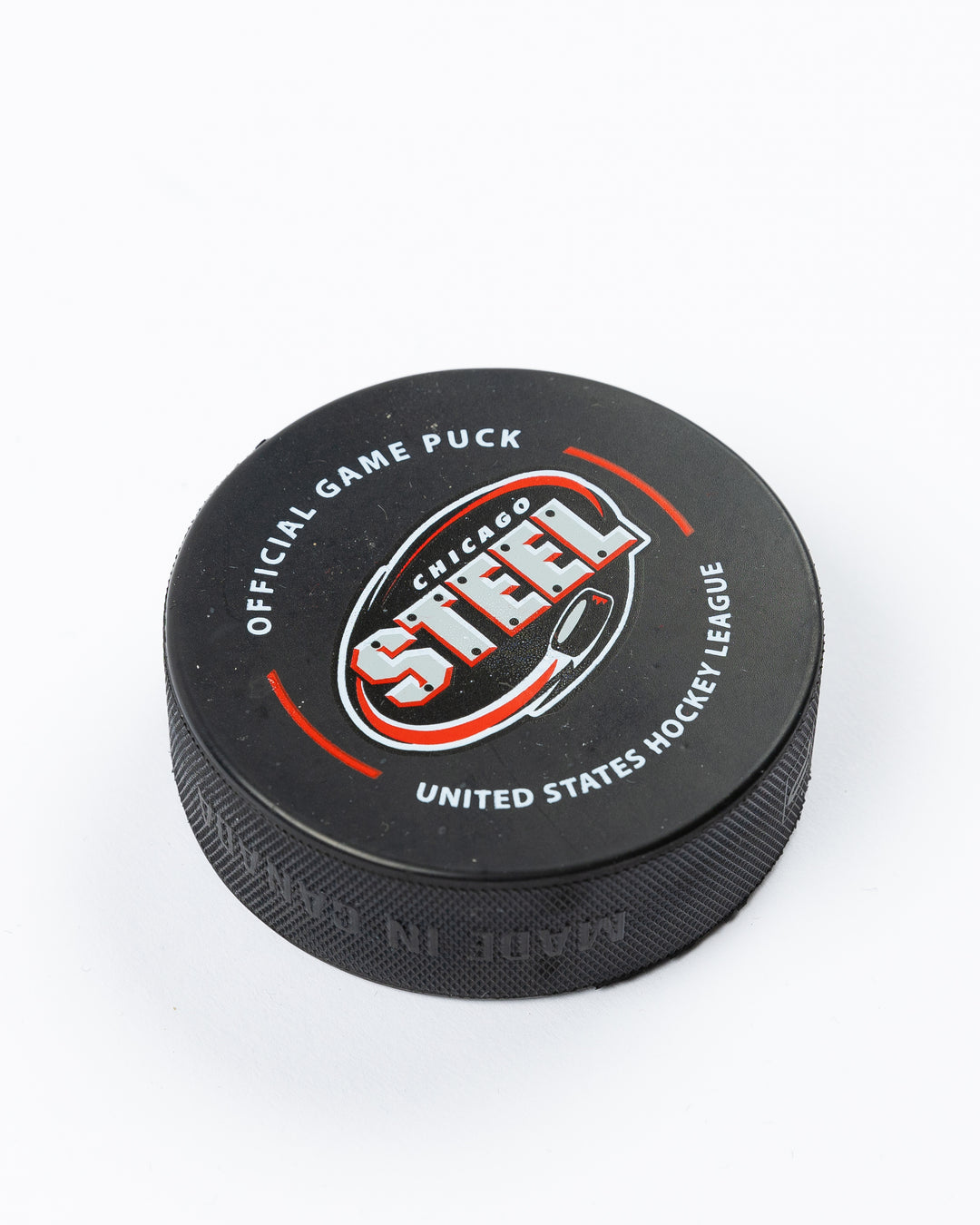 official 23-24 game puck of the Chicago Steel - angled lay flat