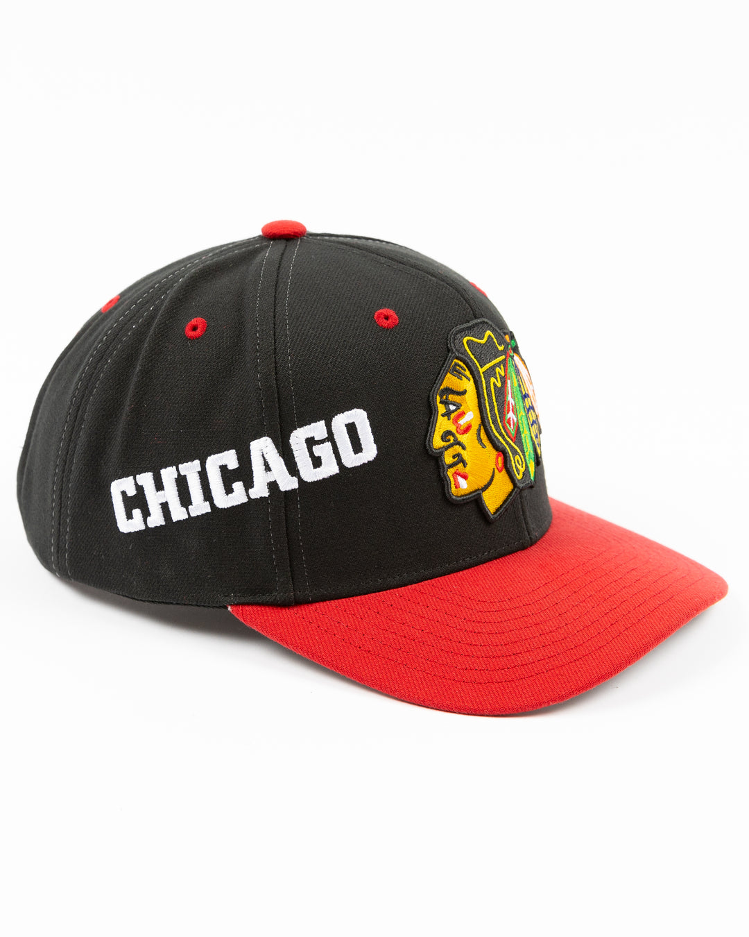 black and red Mitchell & Ness snapback with Chicago Blackhawks primary logo on front, secondary logo on left side and wordmark Chicago on right - right angle lay flat