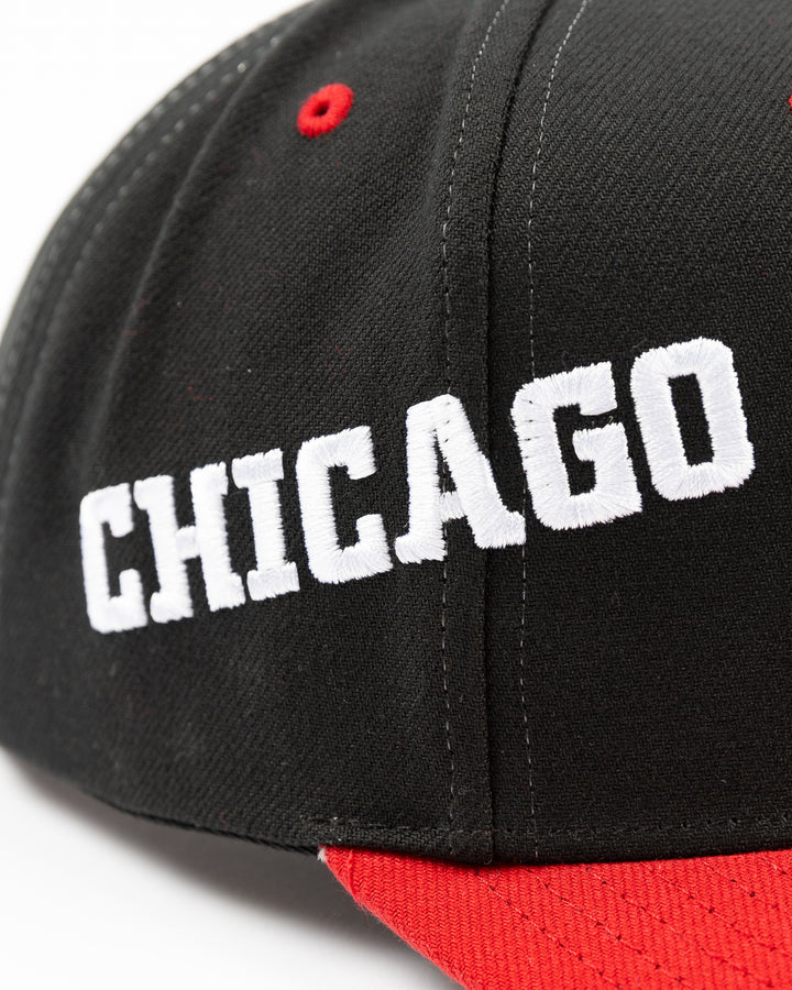 black and red Mitchell & Ness snapback with Chicago Blackhawks primary logo on front, secondary logo on left side and wordmark Chicago on right - right detail lay flat