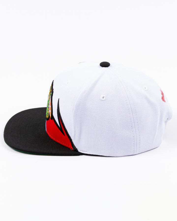 white and black Mitchell & Ness snapback cap with embroidered Chicago Blackhawks primary logo on wave design - left side lay flat