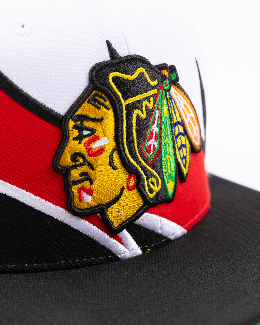 white and black Mitchell & Ness snapback cap with embroidered Chicago Blackhawks primary logo on wave design - front detail lay flat