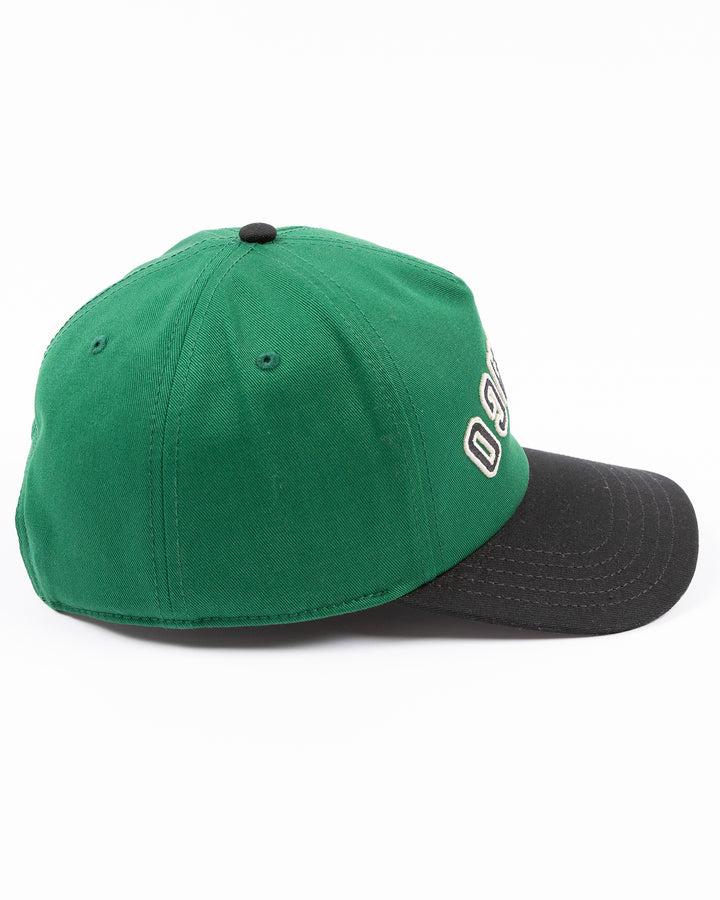 American Needle Roscoe snapback cap in green and black with upside down Chicago wordmark on front and Chicago Blackhawks primary logo on left side - right side lay flat