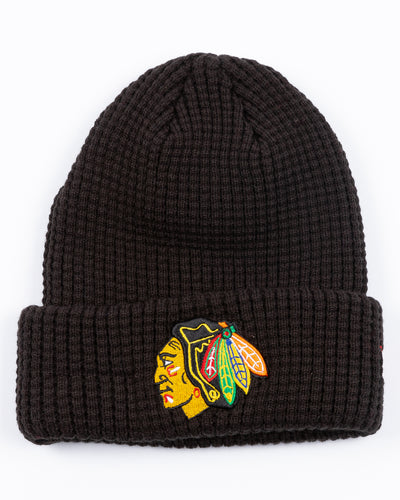 youth New Era black knit waffle beanie with embroidered Chicago Blackhawks primary logo on front cuff - front lay flat