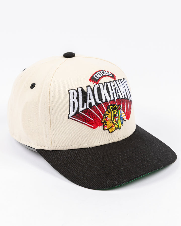 youth cream and black Mitchell & Ness snapback cap with Chicago Blackhawks wordmark and primary logo on front - right angle lay flat