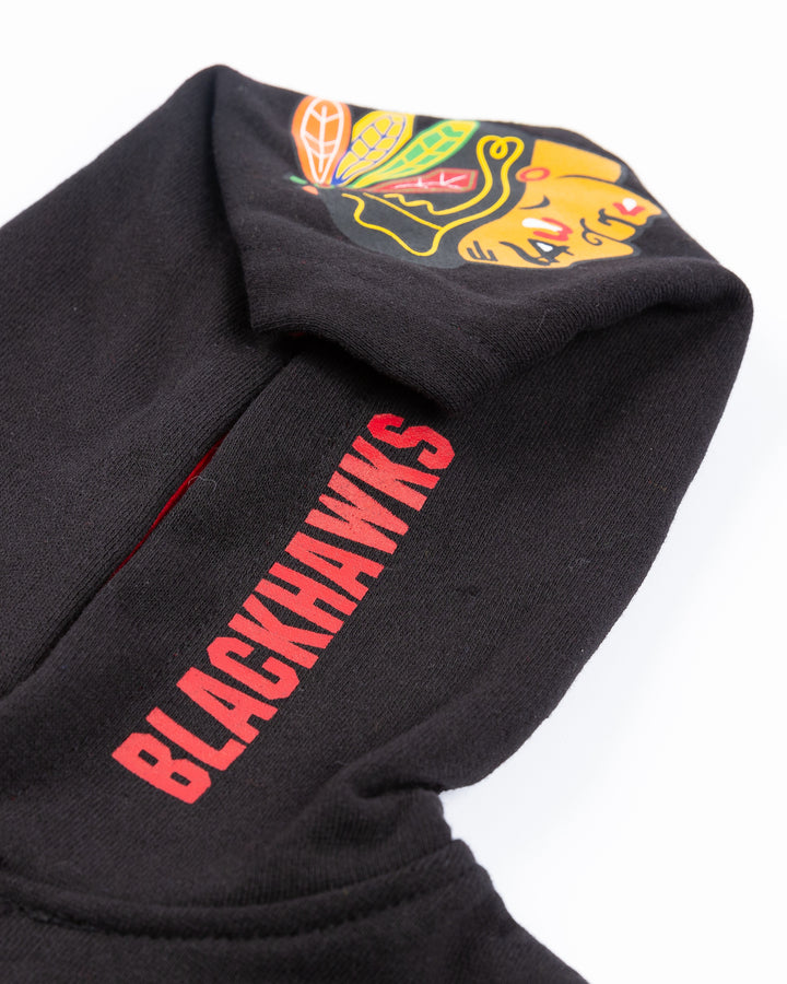 toddler size black hoodie with Chicago Blackhawks primary logo and wordmark on hoodie and layer inspired graphic on front - hood detail lay flat