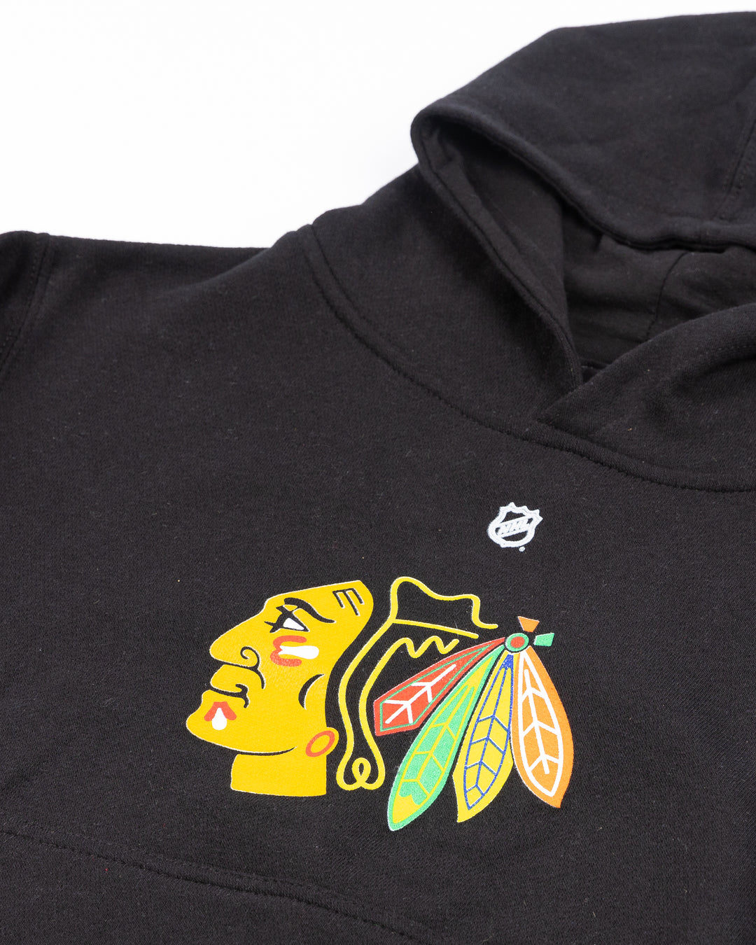 youth black hoodie with Connor Bedard name and number on back and Chicago Blackhawks primary logo on front - front detaillay flat