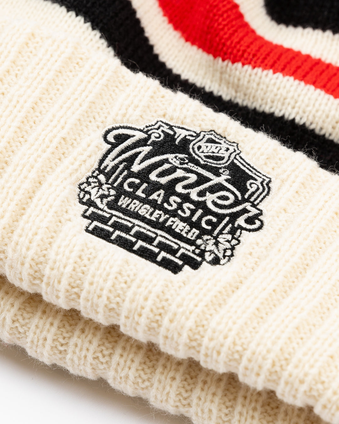 striped cream red and white American Needle knit pom hat with multicolor pom and Chicago Blackhawks secondary logo embroidered on front and NHL Winter Classic logo embroidered on back - back lay flat