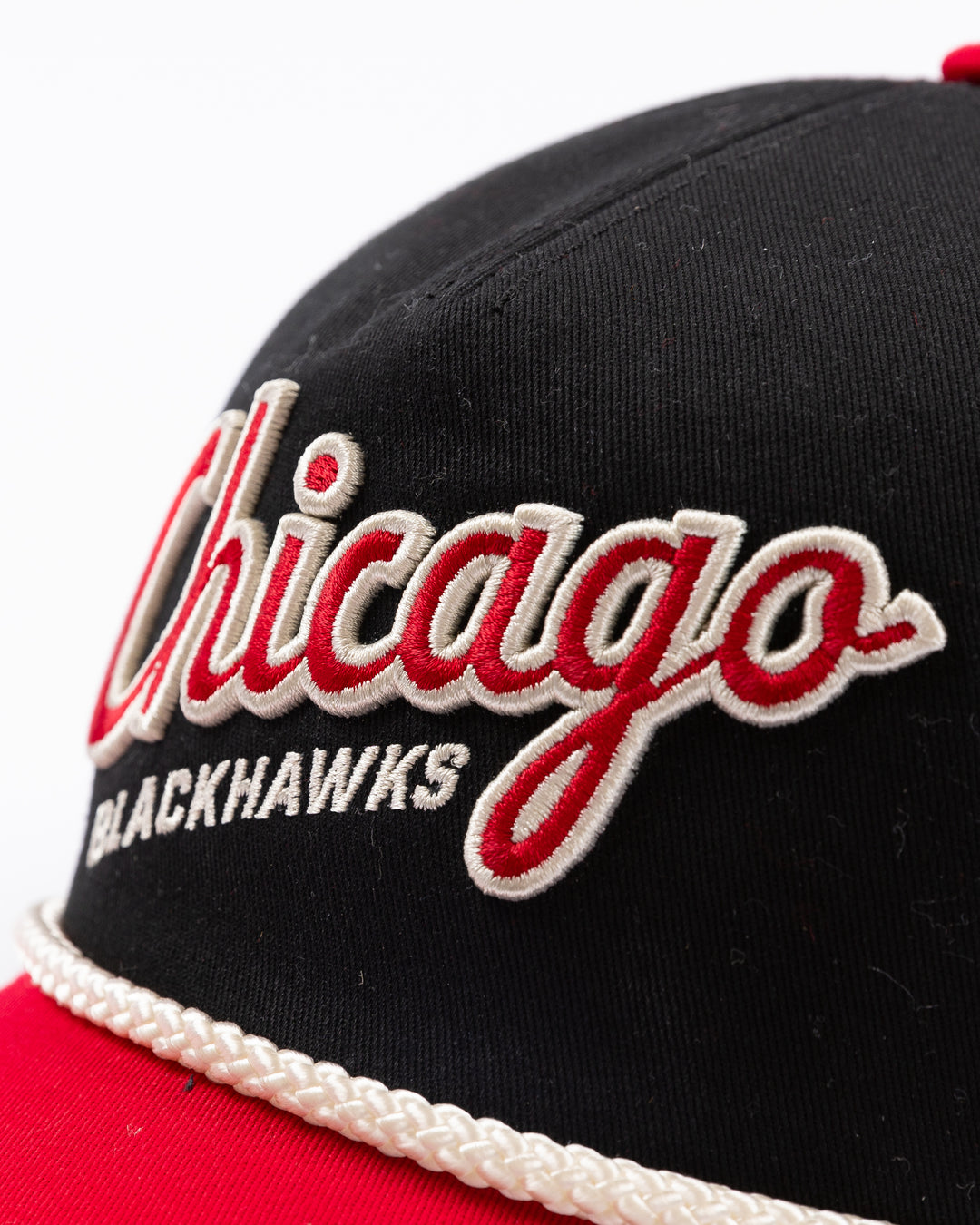 two tone black and red rope American Needle snapback cap with Chicago Blackhawks wodmark embroidered on front and Winter Classic logo embroidered on left side - front detail lay flat