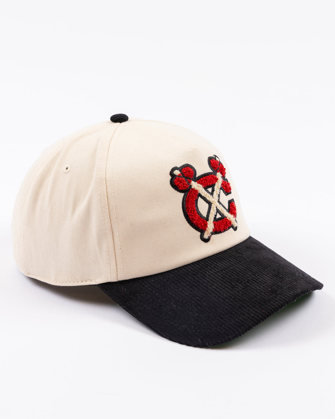 two tone ivory and black American Needle adjustable snapback hat with chenille Chicago Blackhawks secondary logo and Winter Classic logo embroidered on left side - right angle lay flat