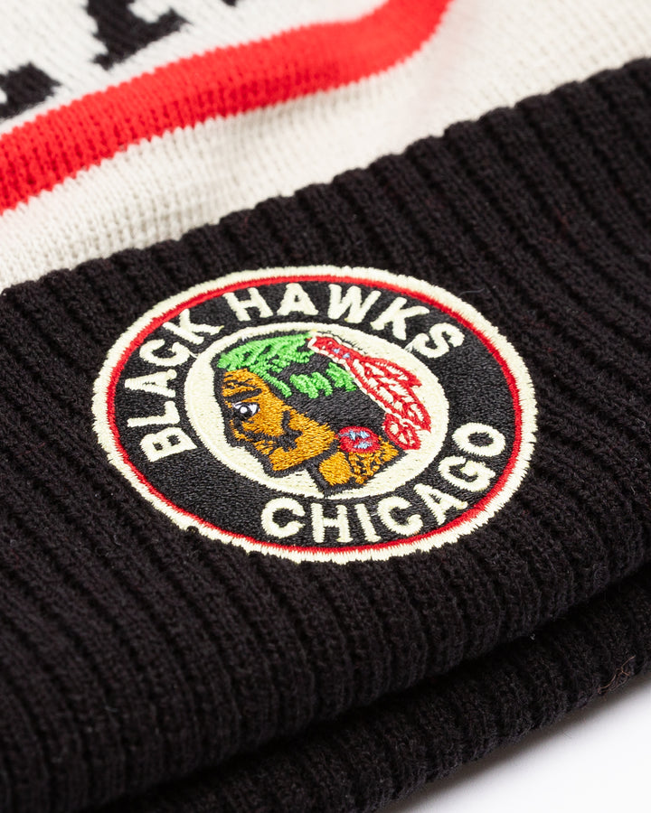 black, white and red CCM beanie with Chicago wordmark on front and vintage Chicago Blackhawks logo on front cuff and black pom on top - front detail lay flat