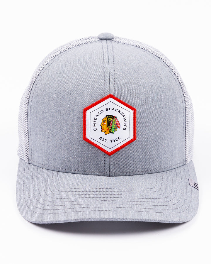 heather grey TravisMathew adjustable trucker cap with hexagon patch on front with Chicago Blackhawks primary logo and wordmark - front lay flat