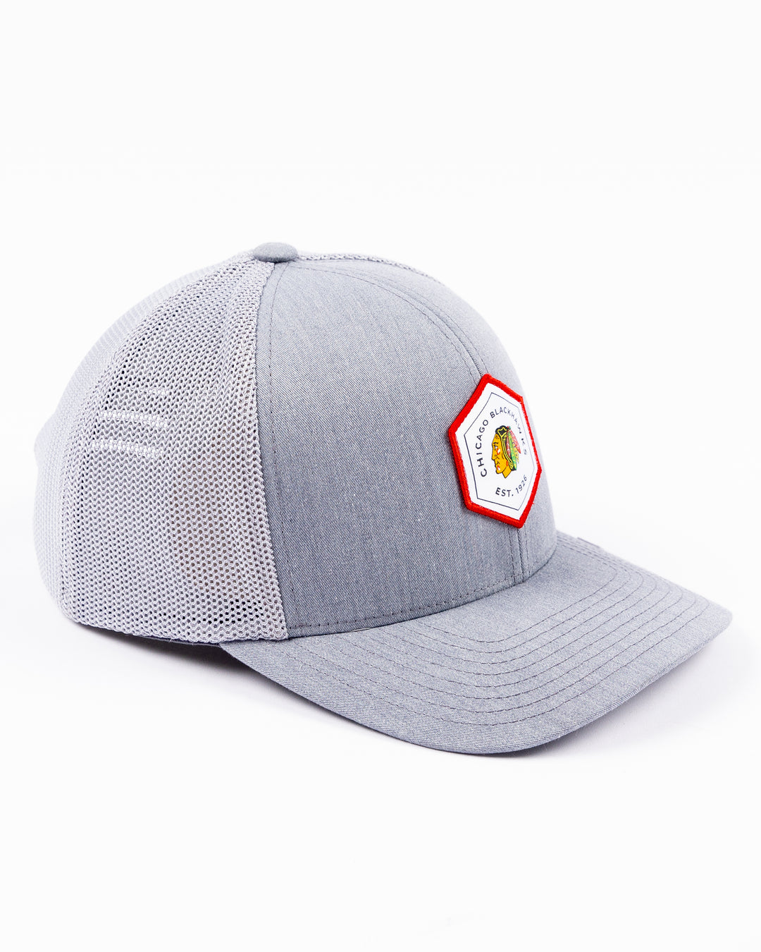 heather grey TravisMathew adjustable trucker cap with hexagon patch on front with Chicago Blackhawks primary logo and wordmark - right angle lay flat