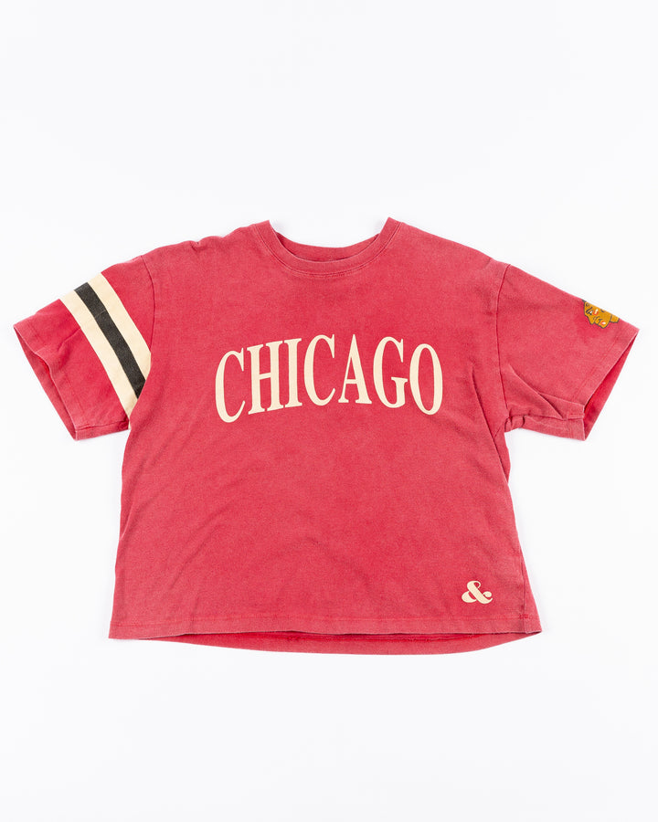 red boxy crop Alice & Wonder tee with Chicago wordmark across front and Chicago Blackhawks primary logo on left sleeve and jersey stripes on right sleeve - front lay flat