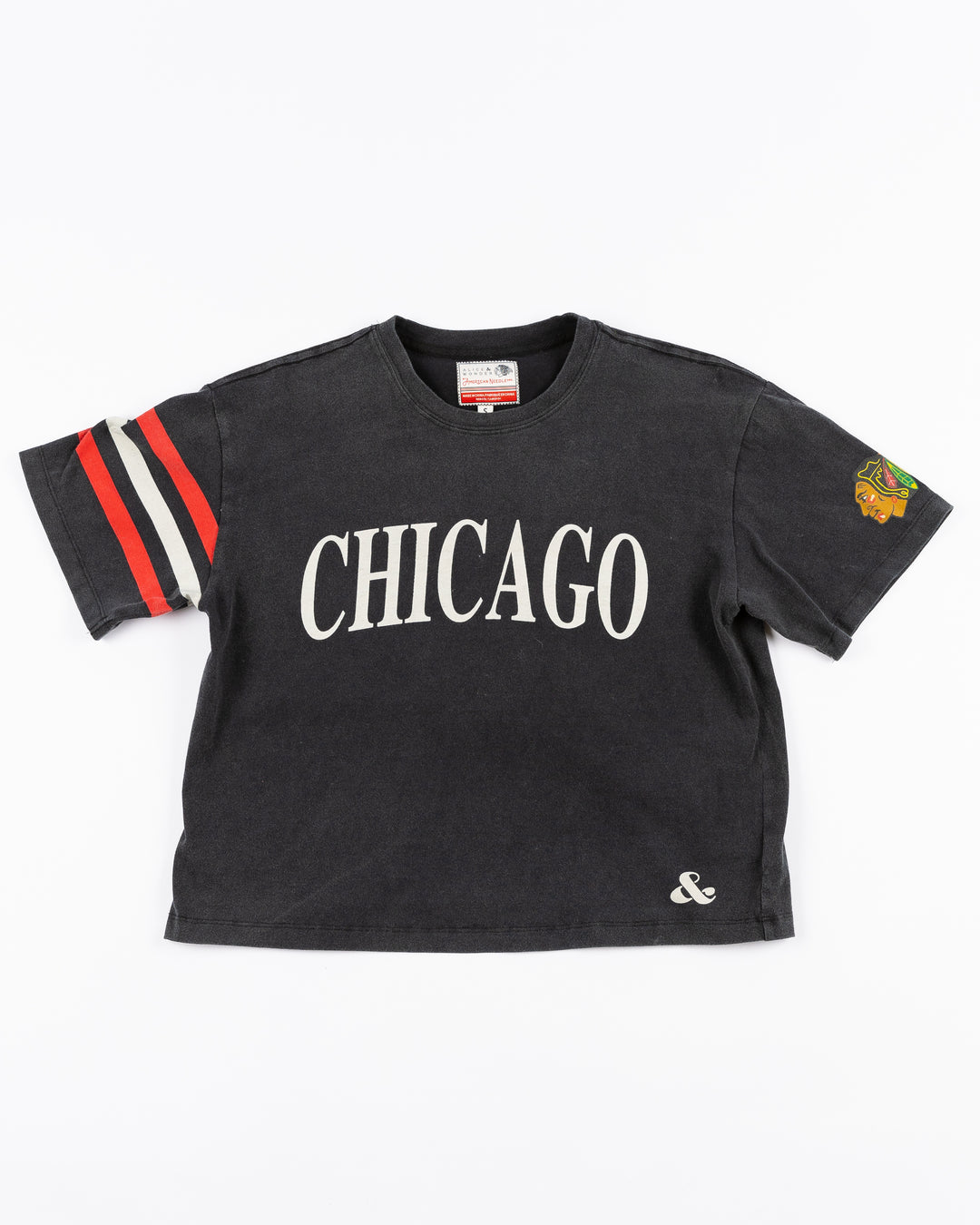 black cropped Alice & Wonder tee with Chicago wordmark graphic across front and Chicago Blackhawks primary logo on shoulder with jersey-inspired stripes on right sleeve - front lay flat