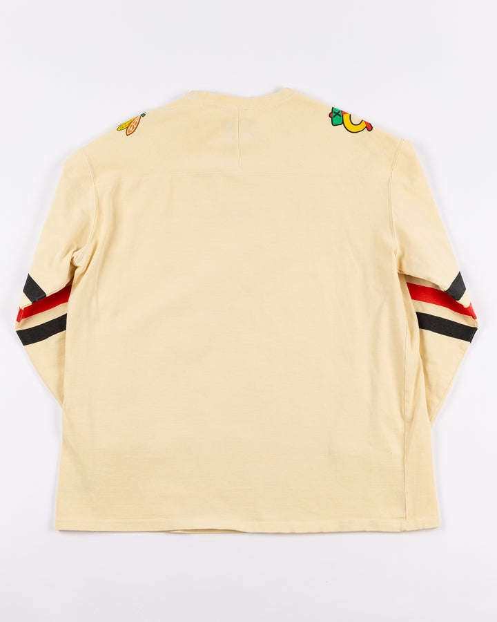 cream Alice & Wonder long sleeve tee with diagonal Chicago wordmark graphic and Chicago Blackhawks secondary and primary logo on shoulders with jersey stripes on sleeves - back lay flat