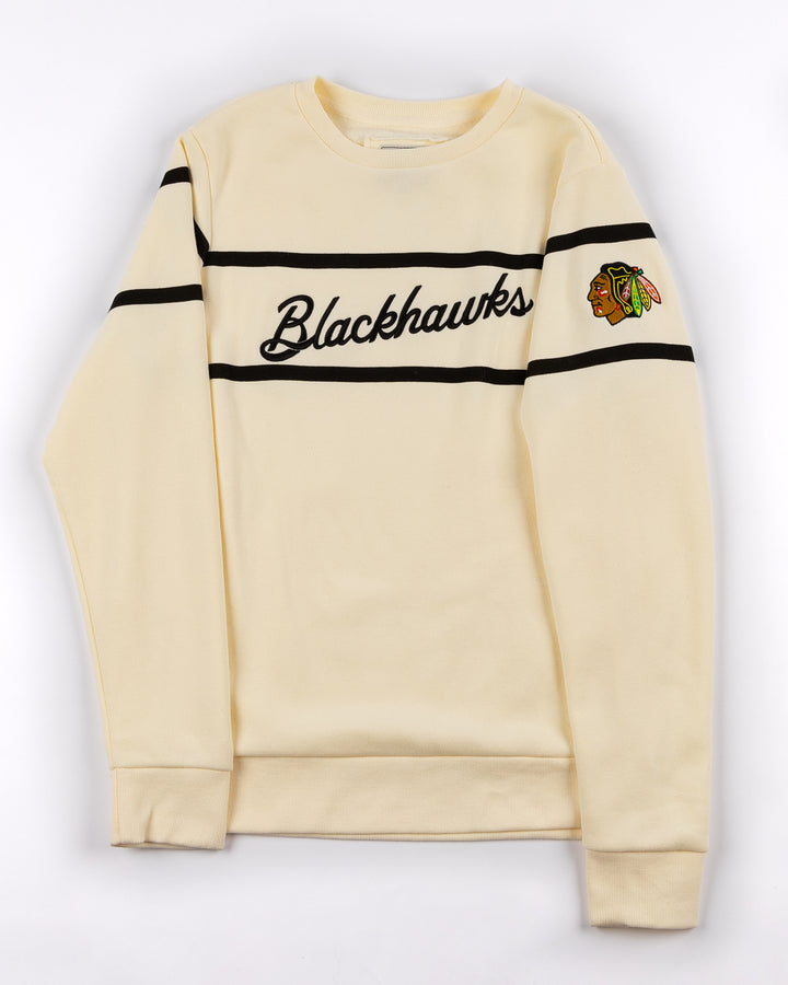 Alice & Wonder cream crewneck sweater with Blackhawks script graphic on front and Chicago Blackhawks primary logo on left shoulder = front lay flat