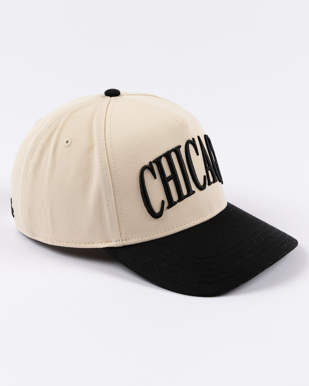 cream and black Alice & Wonder hat with Chicago wordmark on front and Chicago Blackhawks primary logo on left side - right angle lay flat