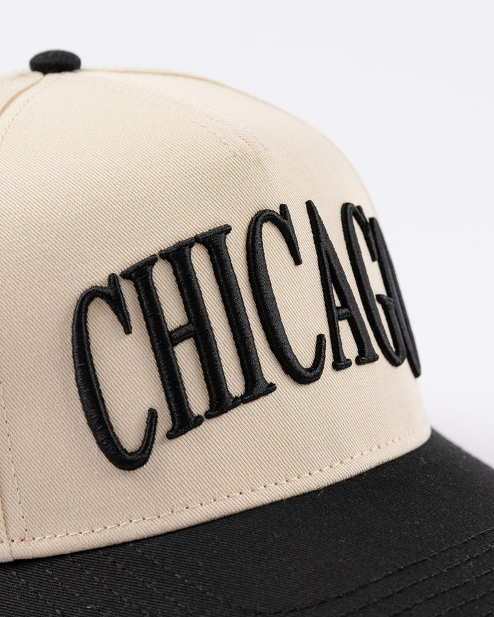 cream and black Alice & Wonder hat with Chicago wordmark on front and Chicago Blackhawks primary logo on left side - front detail lay flat