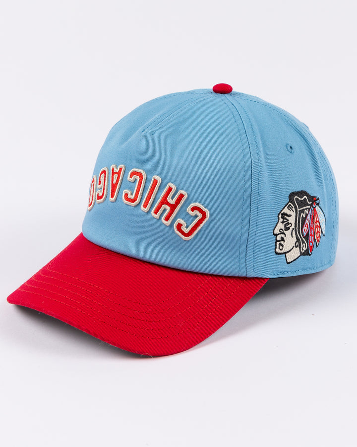 blue and red American Needle hat with upside down Chicago wordmark embroidered on front and Chicago Blackhawks primary logo on left side - left angle lay flat