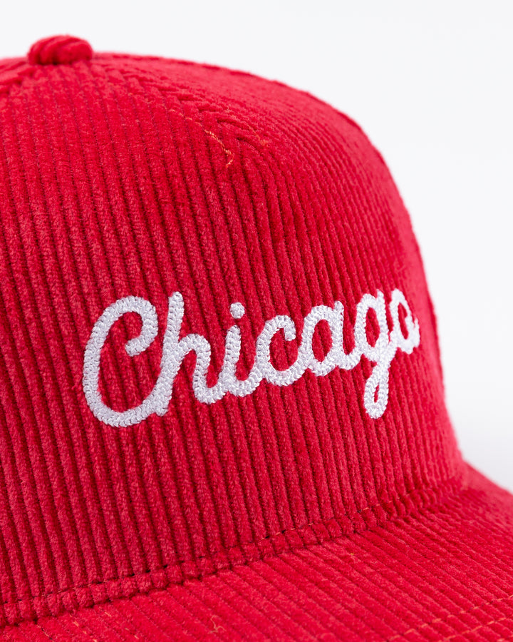 red corduroy Alice & Wonder adjustable hat with white chainstitched Chicago script graphic on front and Chicago Blackhawks primary logo on left side - front detail lay flat