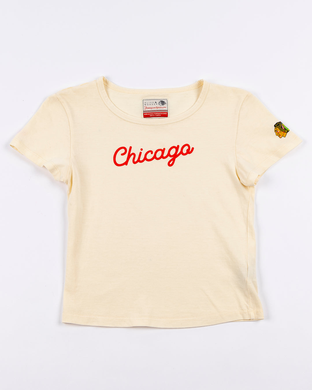 cream Alice & Wonder baby tee with red Chicago script graphic across front and Chicago Blackhawks logo on left sleeve - front lay flat