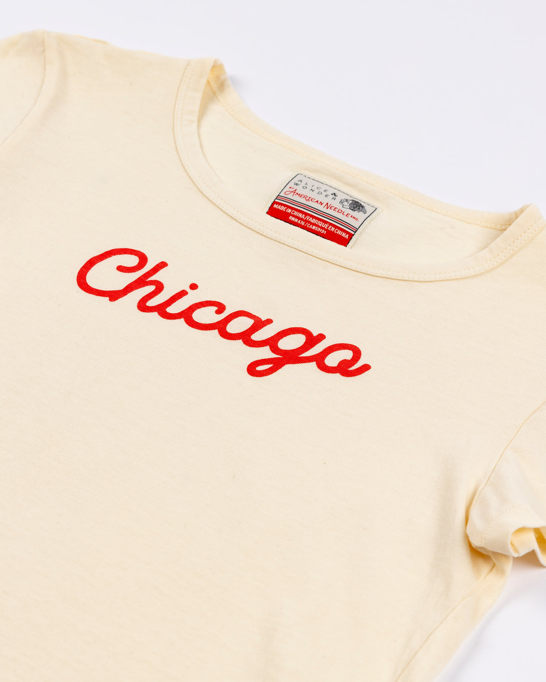 cream Alice & Wonder baby tee with red Chicago script graphic across front and Chicago Blackhawks logo on left sleeve - front detail lay flat