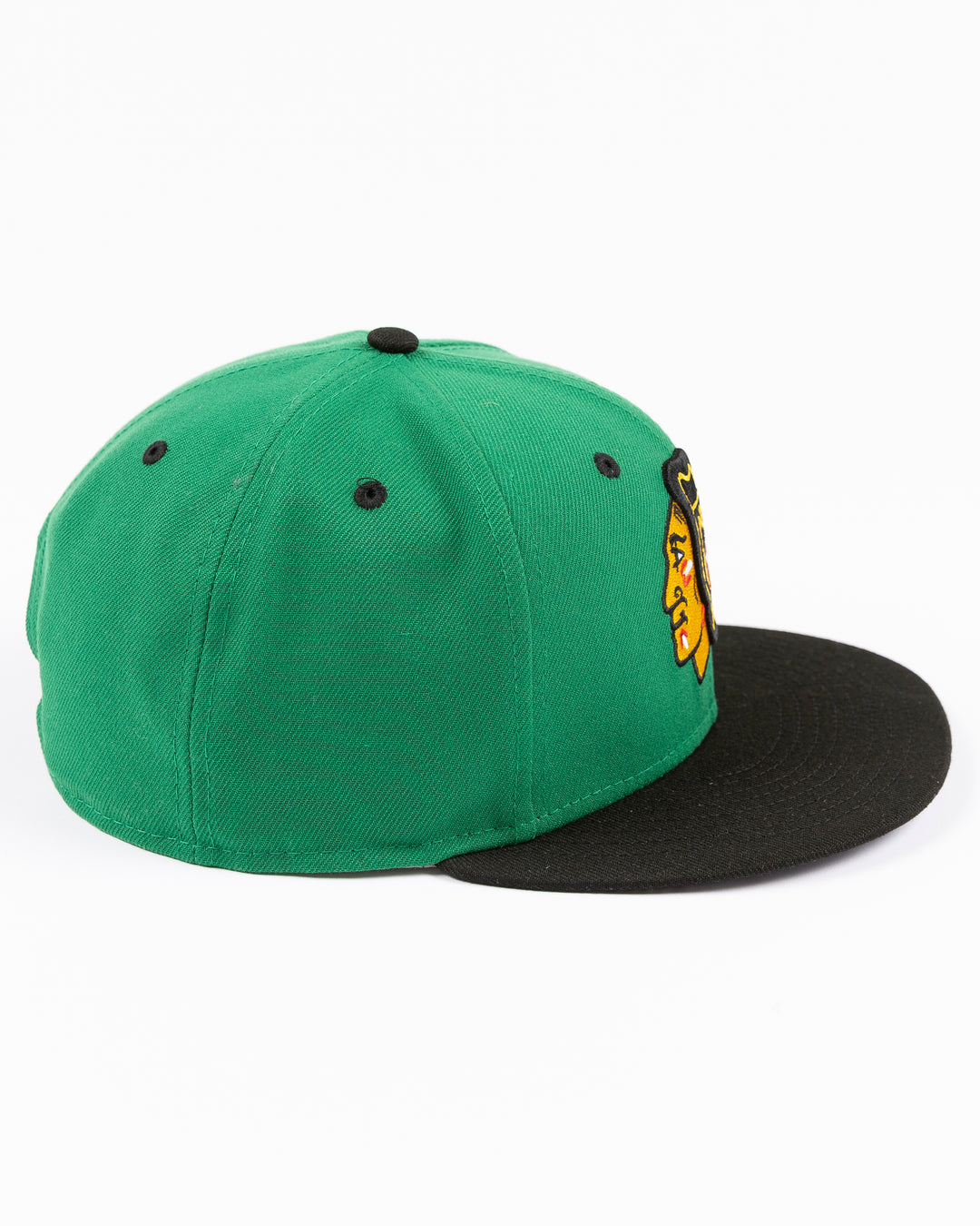 green and black New Era 9FIFTY snapback with Chicago Blackhawks primary logo embroidered on front and black and white star pattern on bottom brim - right side lay flat