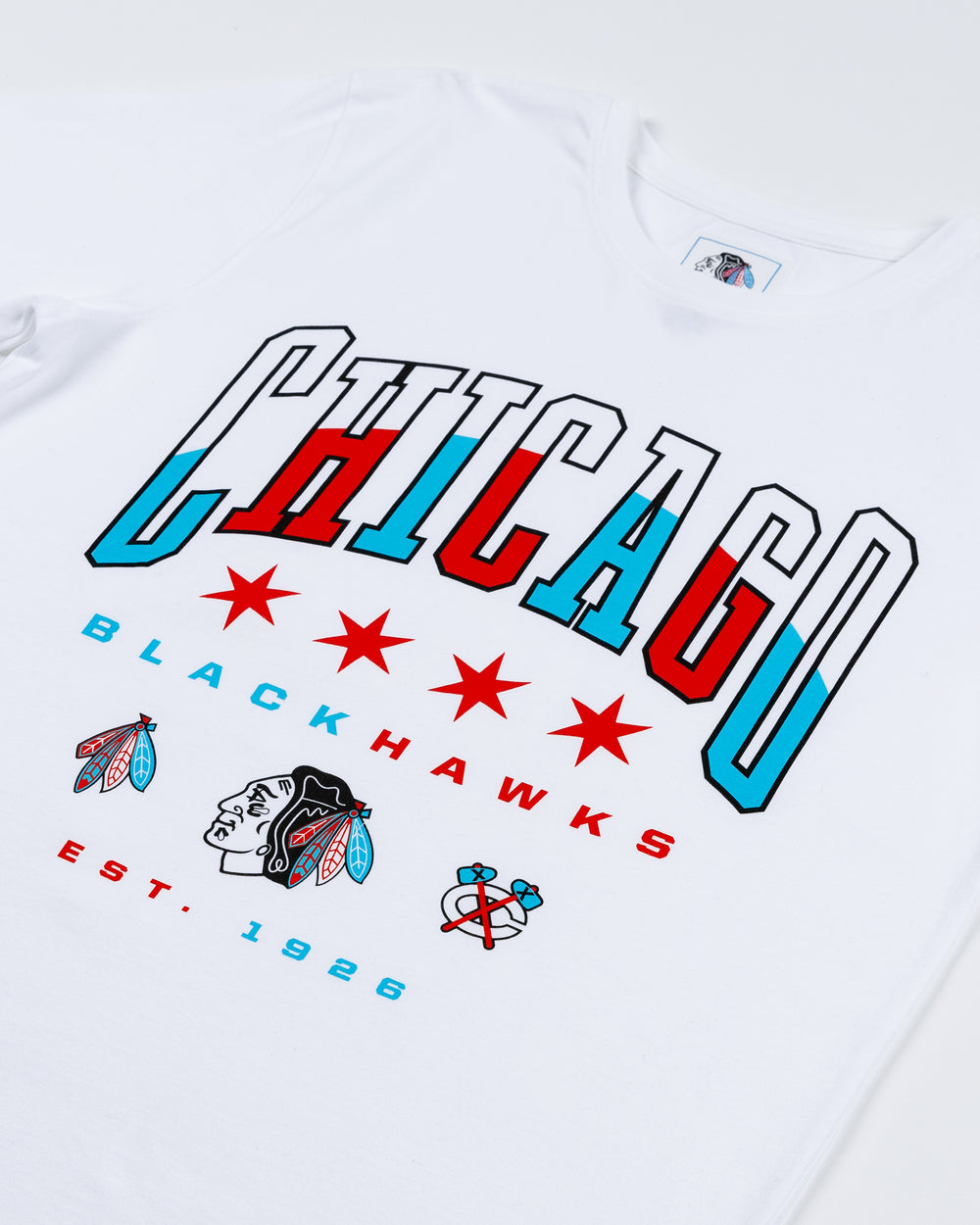 white tee with Chicago wordmark graphic on front and Blackhawks logos below in Chicago flag-inspired colorway- front detail lay flat