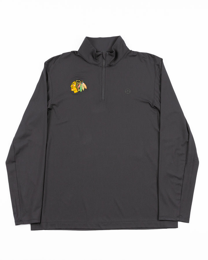 black lululemon half zip golf jacket with Chicago Blackhawks primary logo on right chest - front lay flat