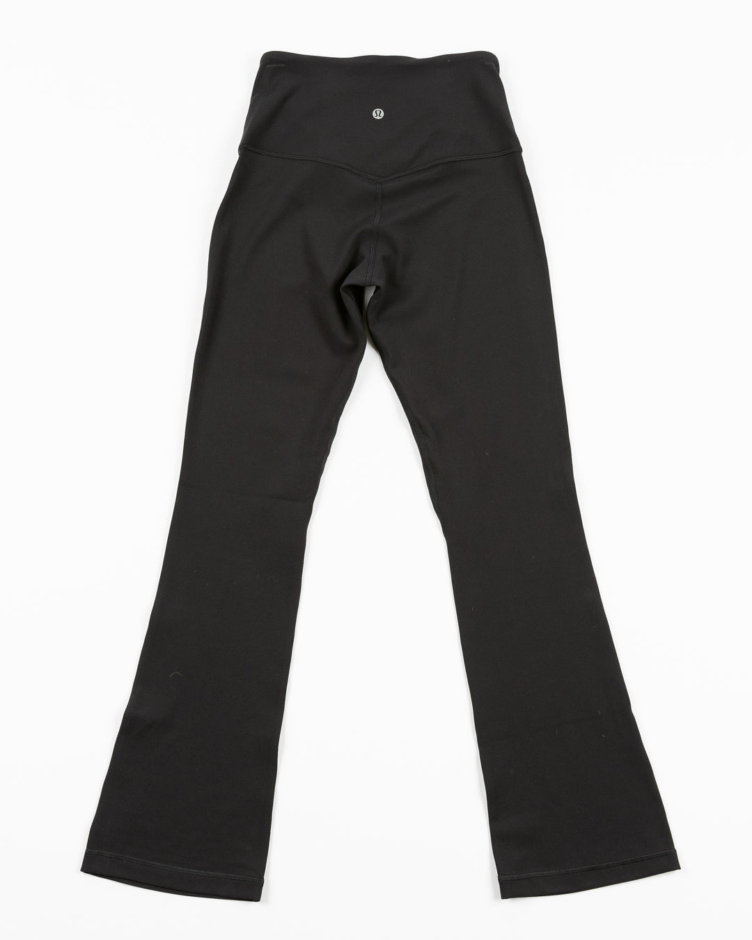 black lululemon legging pants with flare at hem and Chicago Blackhawks wordmark on left thigh - back lay flat