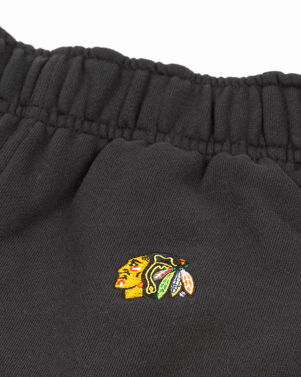 black lululemon women's oversized sweatpants with embroidered Chicago Blackhawks primary logo on left leg - front detail lay flat