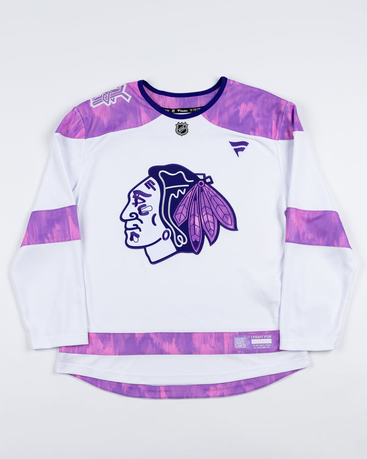 white Fanatics jersey with purple tie dye accents for Hockey Fights Cancer and Chicago Blackhawks tonal primary logo on the front and customizable tag on left hem - front lay flat