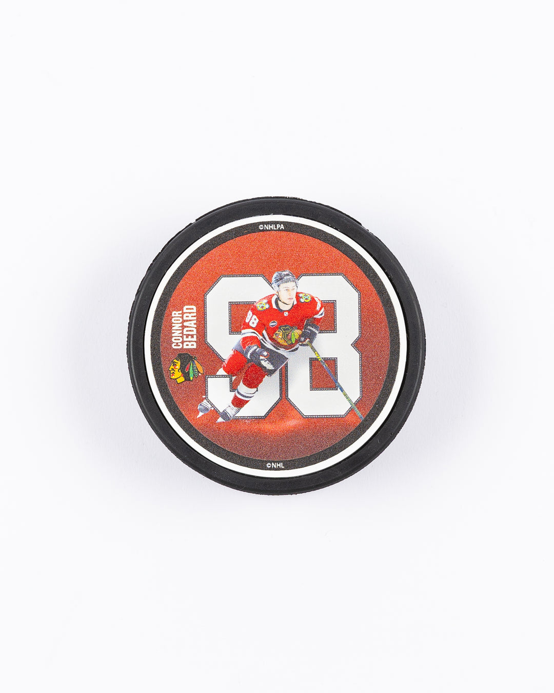 hockey puck with Connor Bedard name and number with action photo and Chicago Blackhawks primary logo - front lay flat