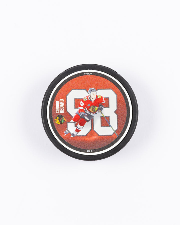 hockey puck with Connor Bedard name and number with action photo and Chicago Blackhawks primary logo - front lay flat