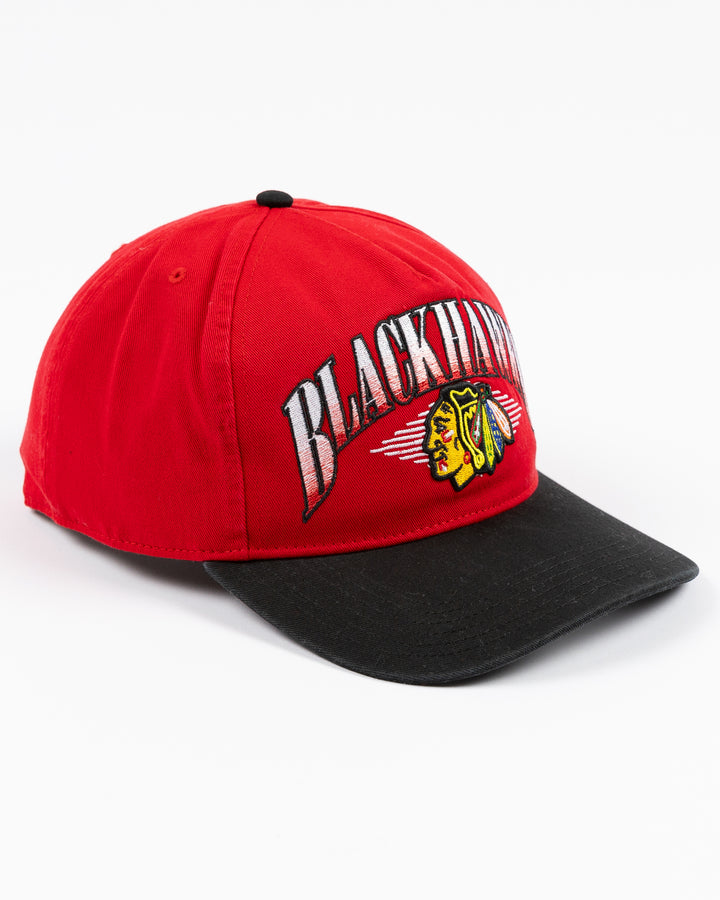 two tone red and black '47 brand adjustable cap with Chicago Blackhawks wordmark and primary logo embroidered on front - right angle lay flat