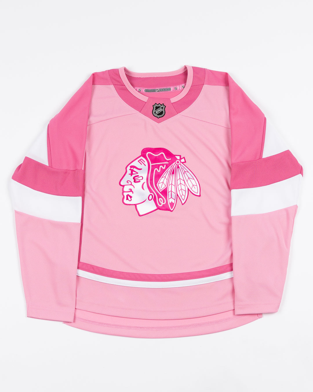 blank pink toddler hockey jersey with Chicago Blackhawks primary logo on front - front lay flat