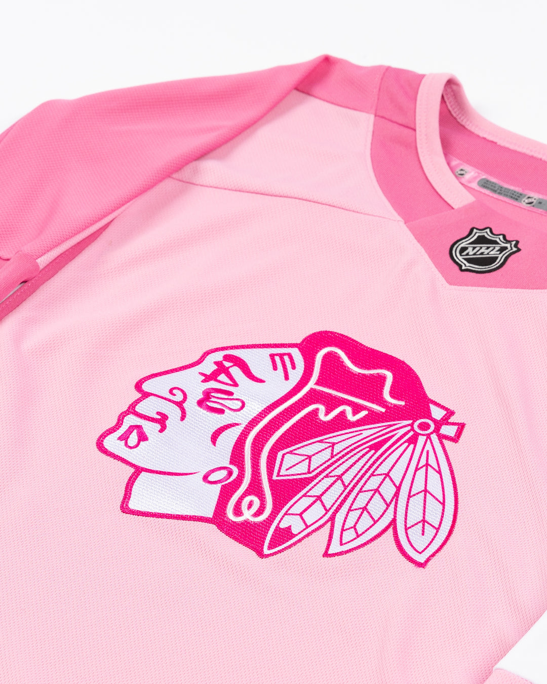 blank pink toddler hockey jersey with Chicago Blackhawks primary logo on front - front detail lay flat