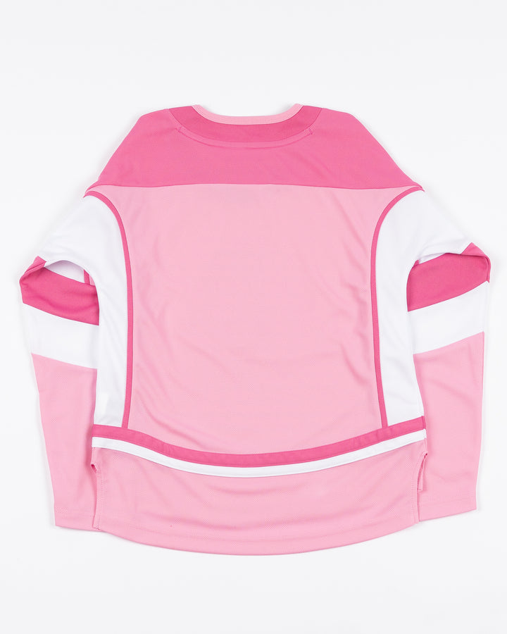 blank pink toddler hockey jersey with Chicago Blackhawks primary logo on front - back lay flat