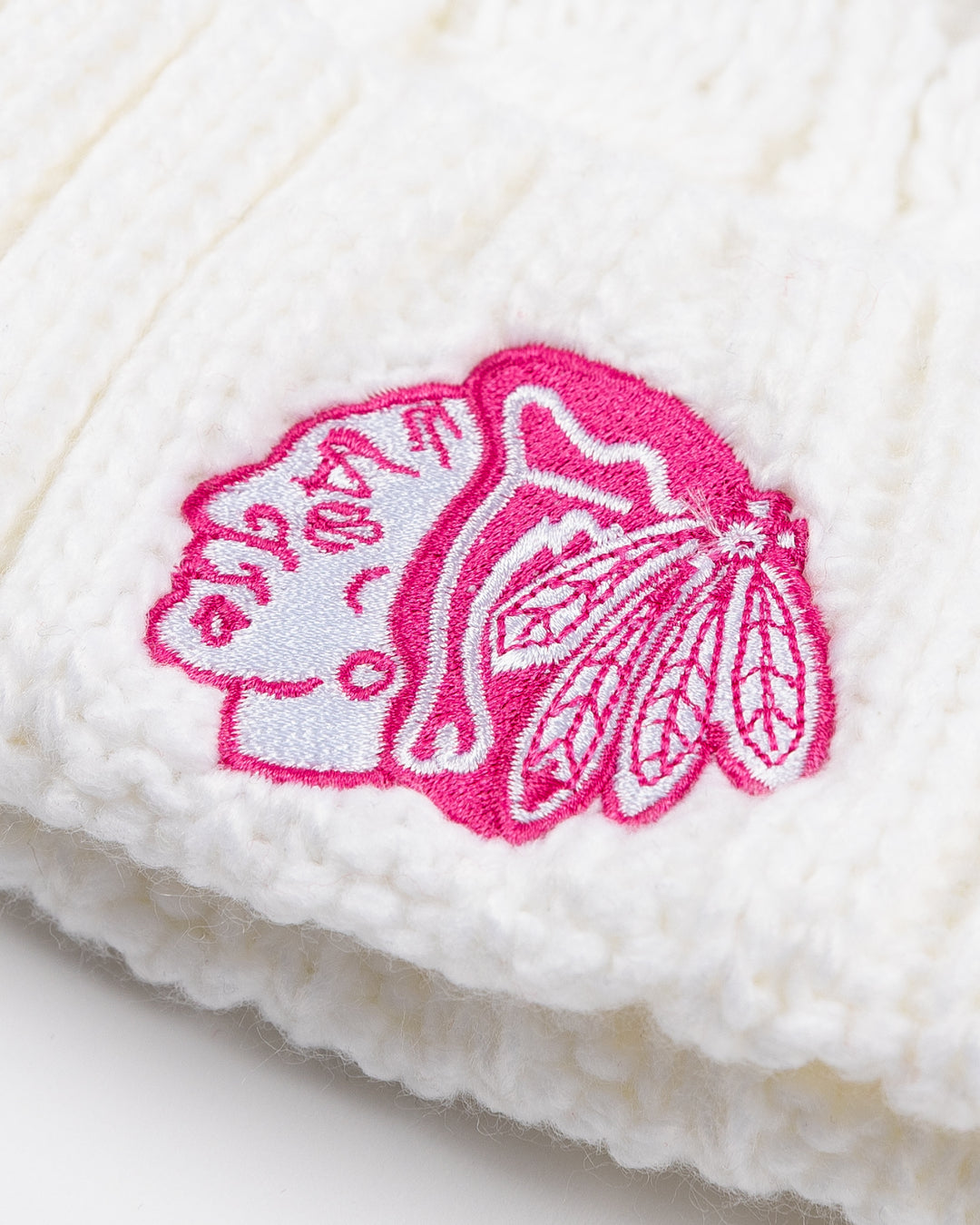 white Outerstuff youth knit hat with white pom and pink tonal Chicago Blackhawks primary logo embroidered on front - front detail lay flat