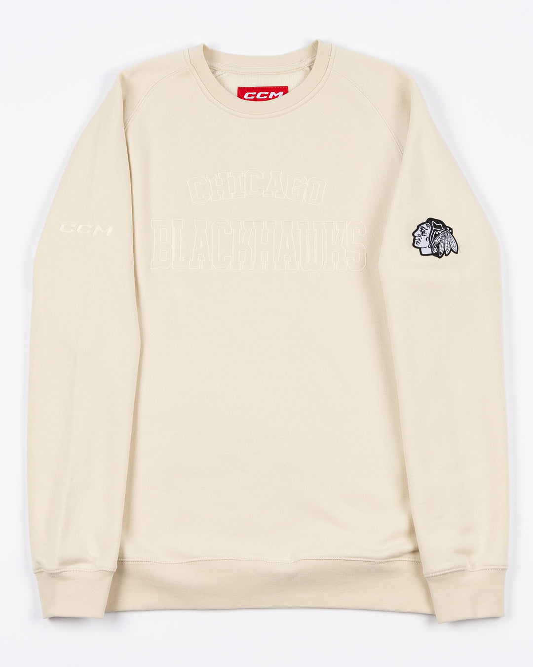 cream CCM crewneck sweater with tonal Chicago Blackhawks wordmark across front and black and white primary logo embroidered on left shoulder - front lay flat